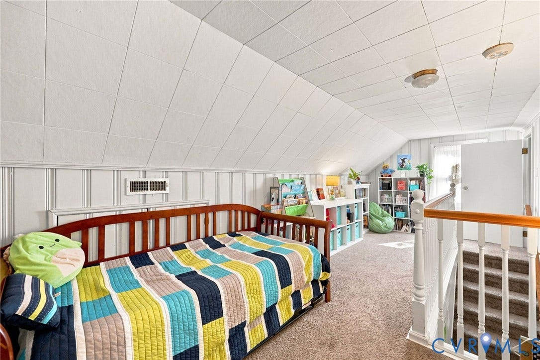Carpeted flooring, sloped ceiling with paneling, white vertical paneling, and white baluster railing