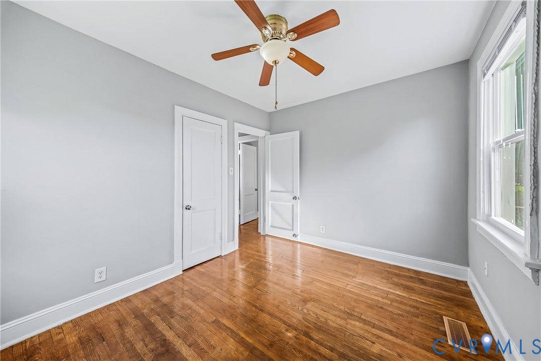 Wood flooring with white trim and light gray walls