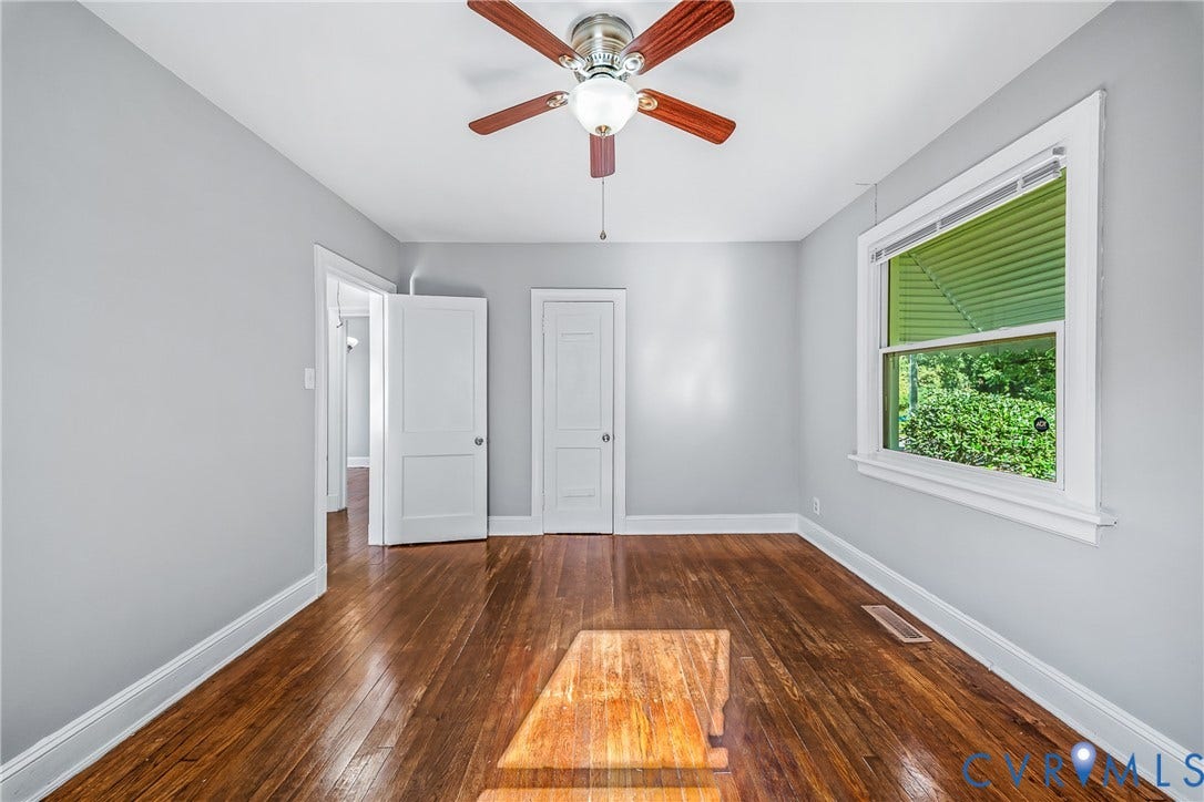 Hardwood flooring, ceiling fan, white trim, and a window with natural light