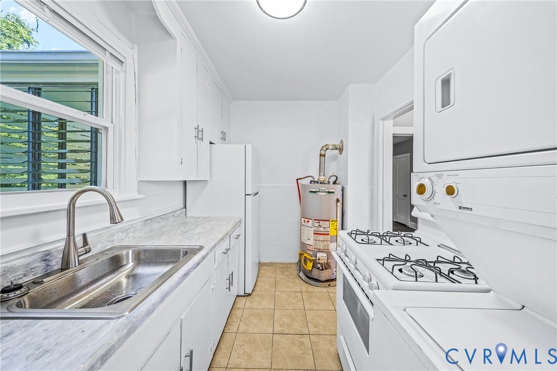White cabinetry and appliances, stainless steel sink, and light-toned countertop