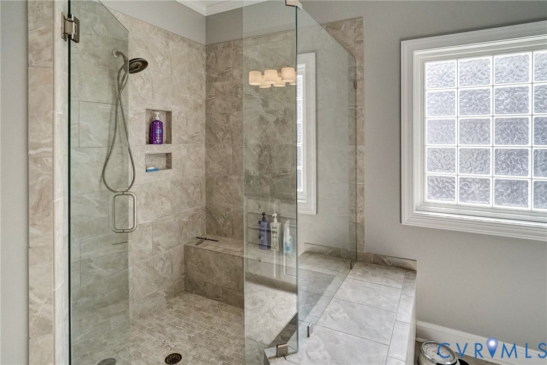 4938 Grey Oaks Villas Drive, Glen Allen, VA 23059 Glass-enclosed shower with stone-look tile walls, a built-in bench, and recessed shelving