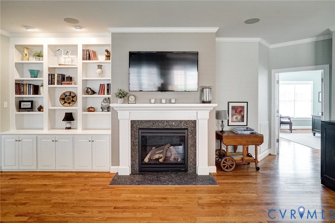 4938 Grey Oaks Villas Drive, Glen Allen, VA 23059 Hardwood flooring complemented by a fireplace featuring a white mantel and dark stone surround