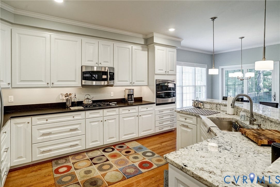 4938 Grey Oaks Villas Drive, Glen Allen, VA 23059 Kitchen featuring white cabinetry, stainless steel appliances, light-toned wood-finish flooring, and light-toned stone countertops