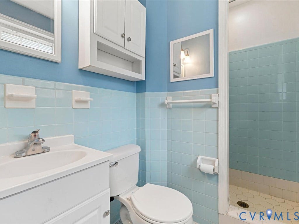 4630 Melody Court, Meadowbrook West, North Chesterfield, VA 23234 Full bathroom with a single vanity, a toilet, a shower stall with tiled walls, a medicine cabinet, and a wall-mounted cabinets