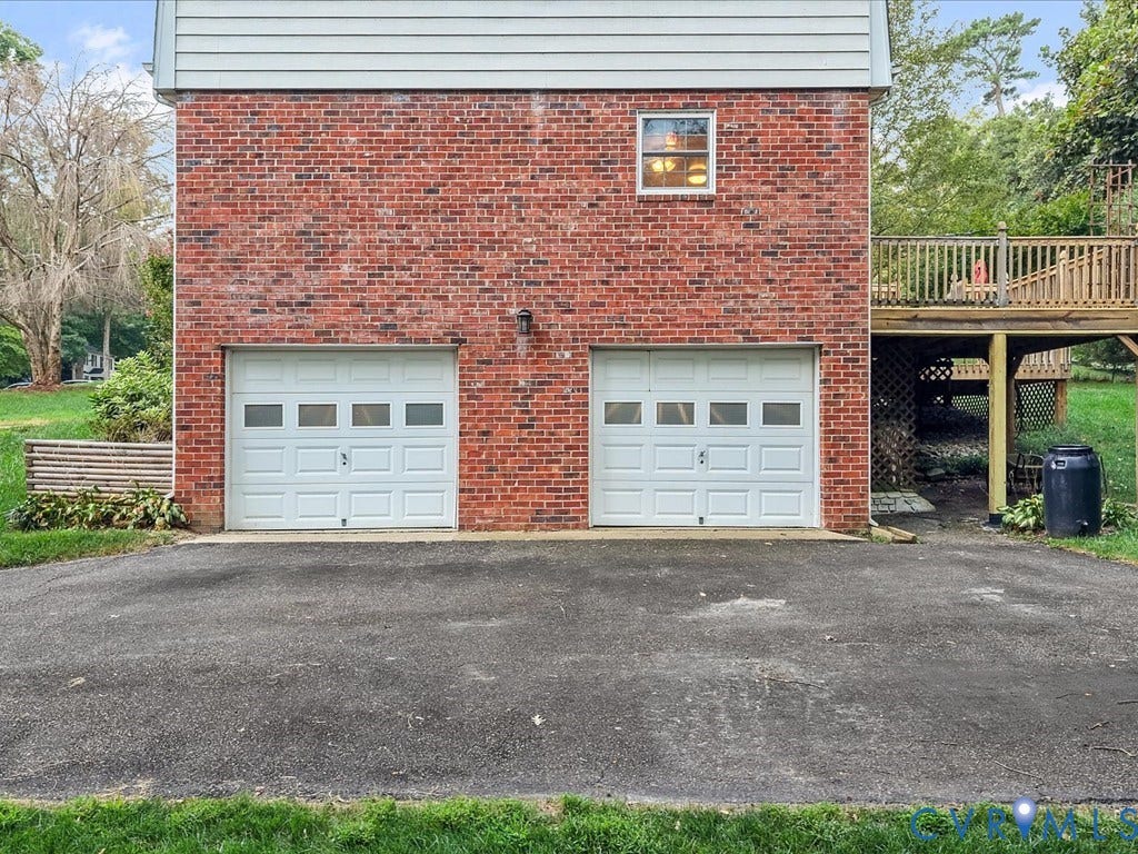4630 Melody Court, Meadowbrook West, North Chesterfield, VA 23234 Dual-bay garage with white paneled doors and asphalt driveway, complemented by a brick exterior.