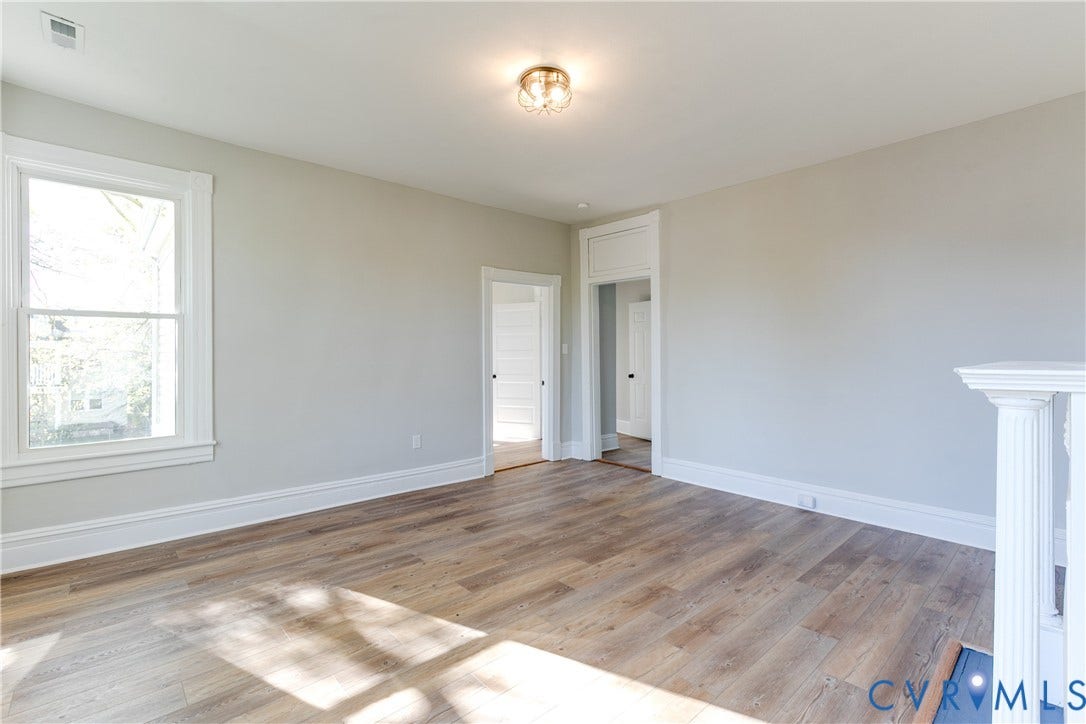 Wood-finish flooring, white trim, recessed lighting, and a white baluster