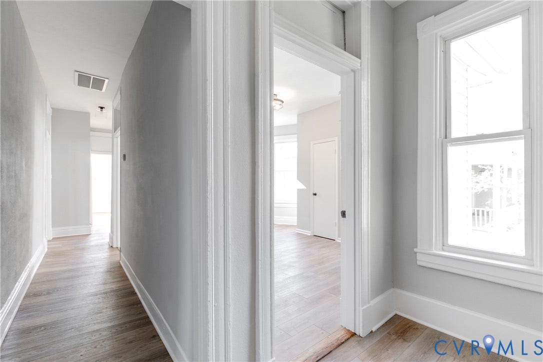 Light wood-finish flooring, white trim, and a single-hung window with a white frame