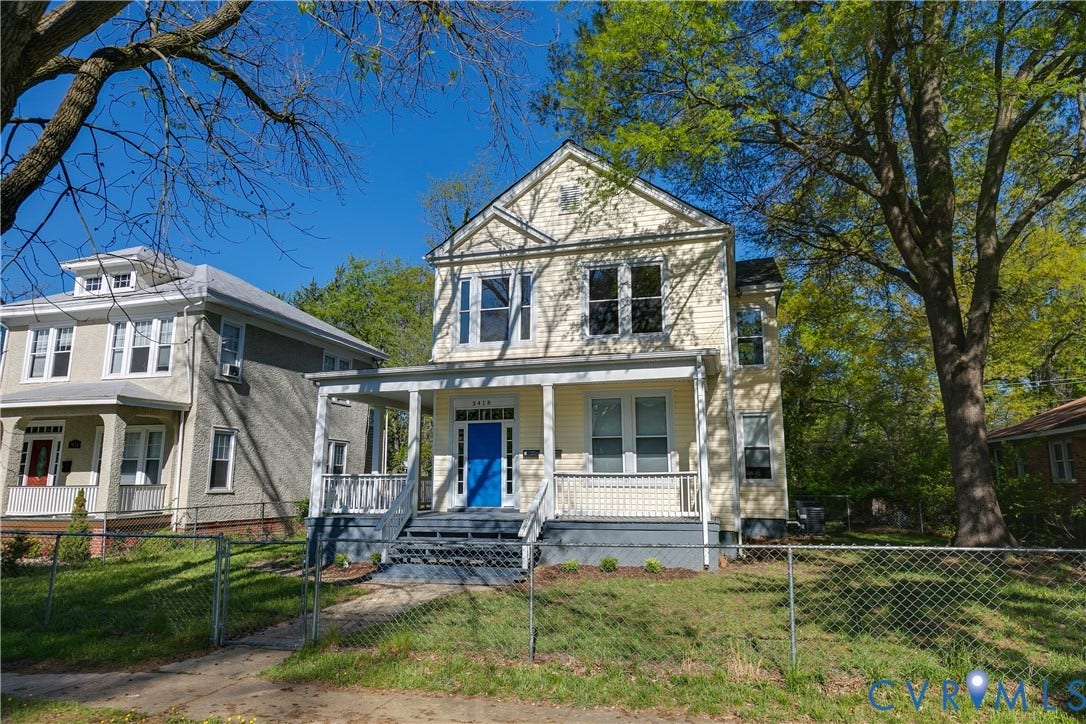 Two-story residence with a covered front porch and a prominent blue entry door