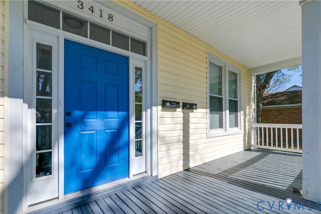 Inviting covered porch with painted wood flooring and white railing