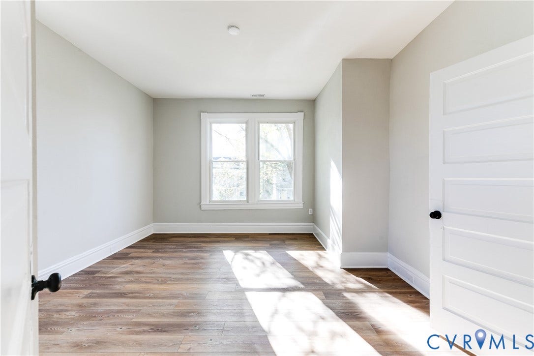 Recessed lighting, wood-finish flooring, white trim, paneled door, and double-hung windows