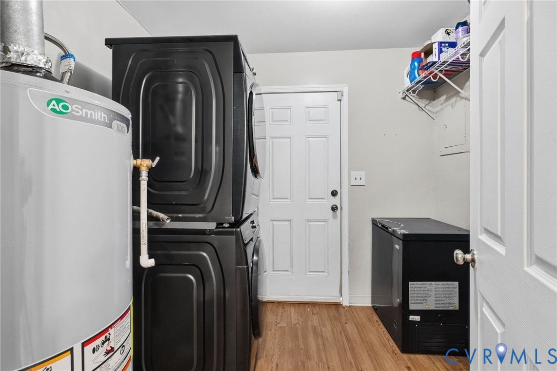4429 Crown Squire Road, Henrico, VA 23231 Laundry area featuring a stacked washer and dryer, wood-finish flooring, and wall-mounted shelving