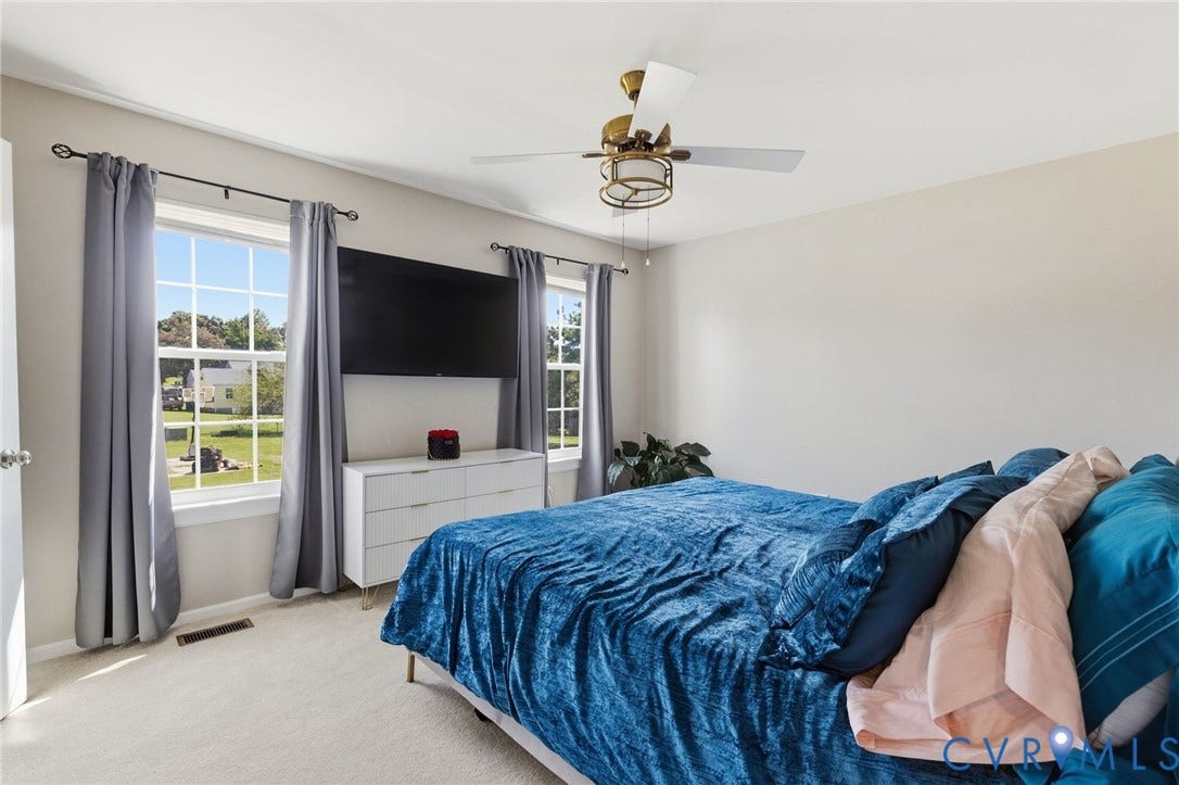 4429 Crown Squire Road, Henrico, VA 23231 Bright interior with light-colored carpeting, multiple windows providing natural illumination, and a ceiling-mounted fan with integrated lighting