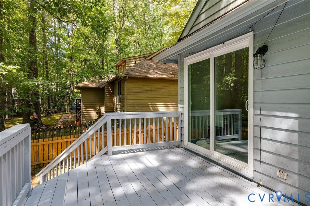 Spacious outdoor deck with painted wood flooring and railing