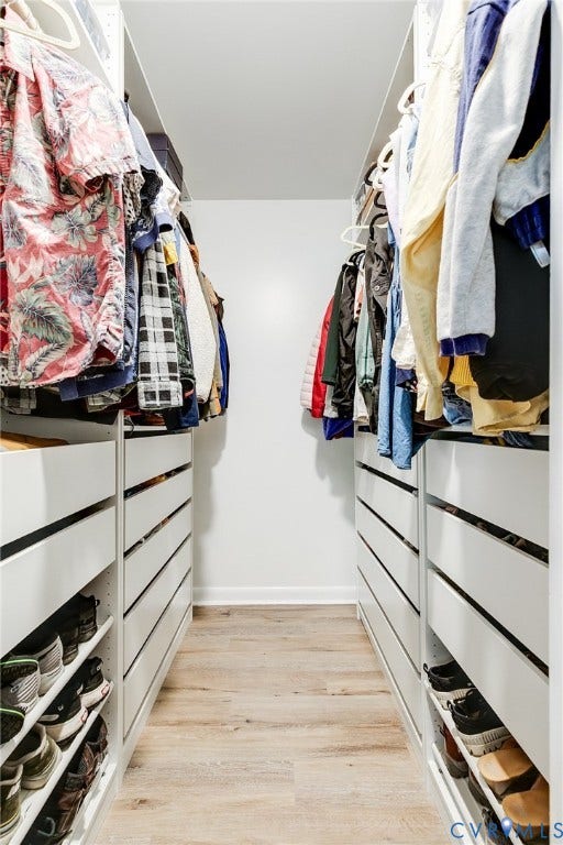 Custom closet system with integrated shelving, built-in drawer storage, and wood-finish flooring