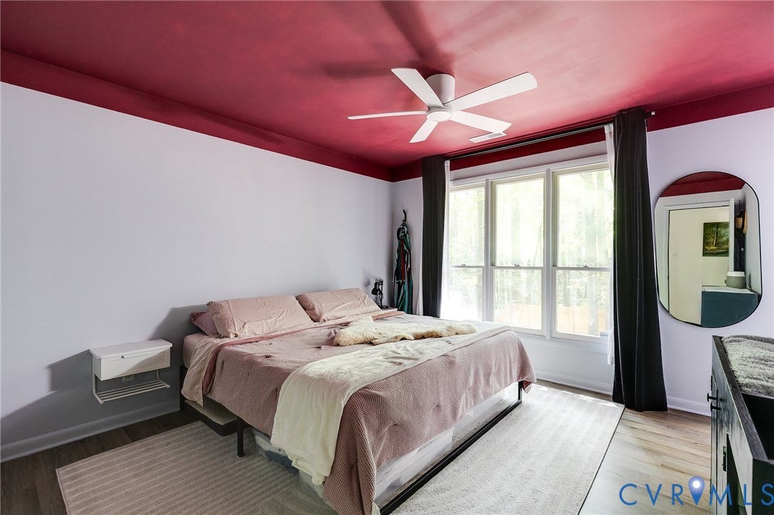 Wood-finish flooring, white ceiling fan, and a three-panel window