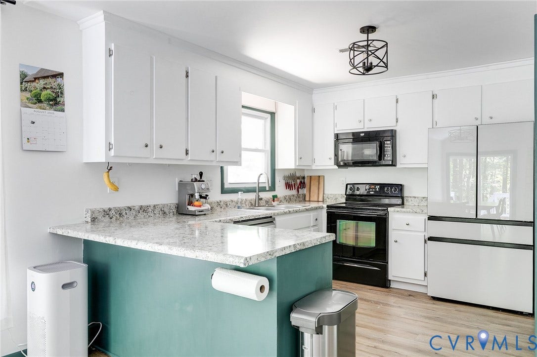 Wood-finish flooring with white cabinetry and light-colored countertops
