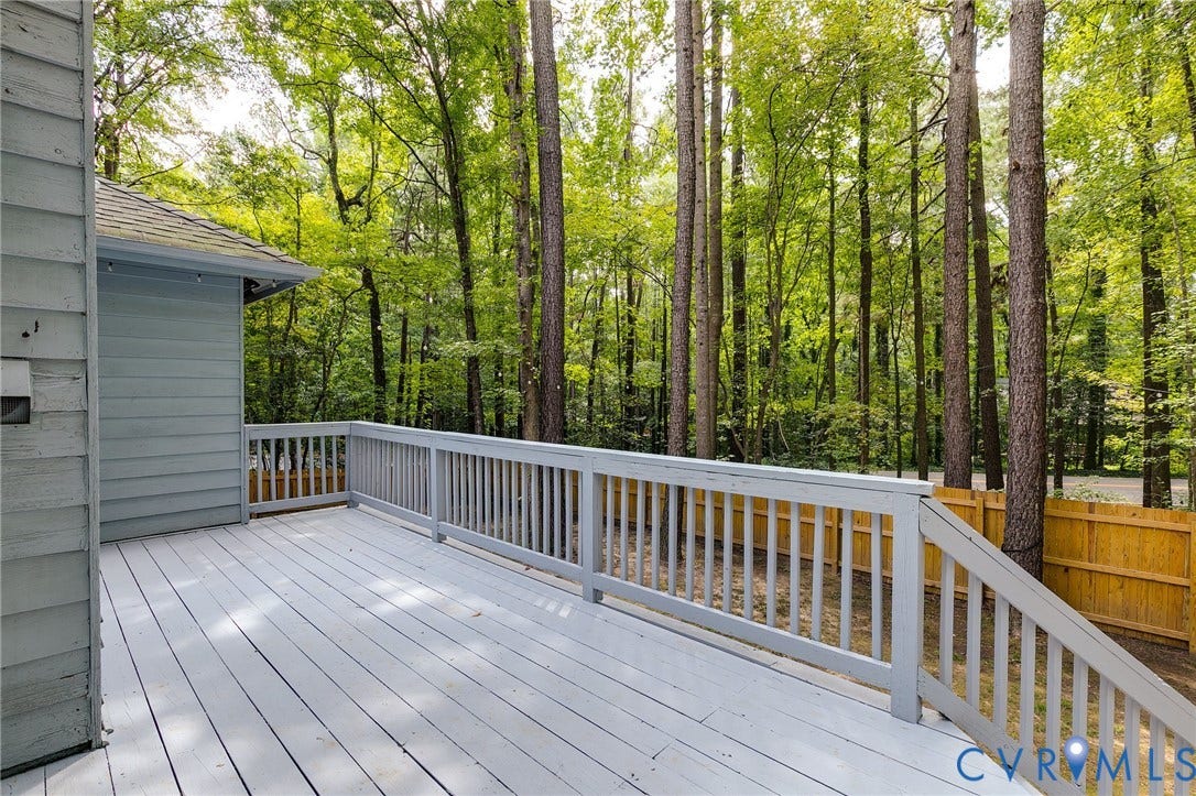 Expansive exterior deck with painted wood flooring and matching railings