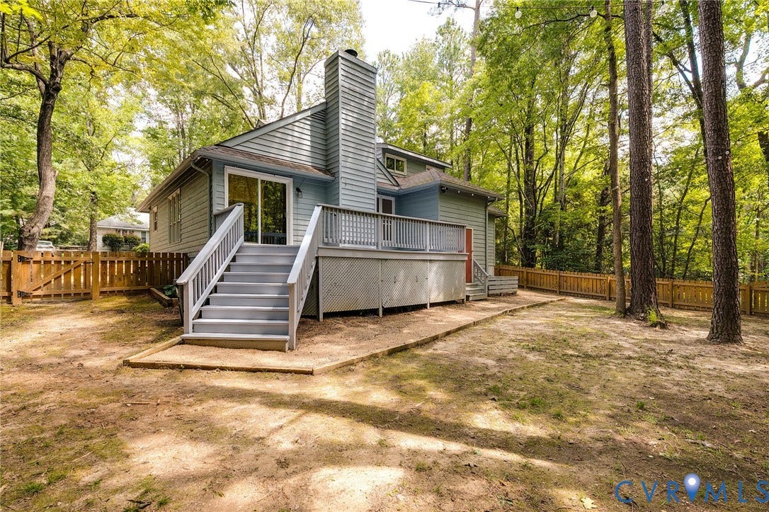 Expansive backyard featuring a multi-level deck, privacy fencing, and mature trees