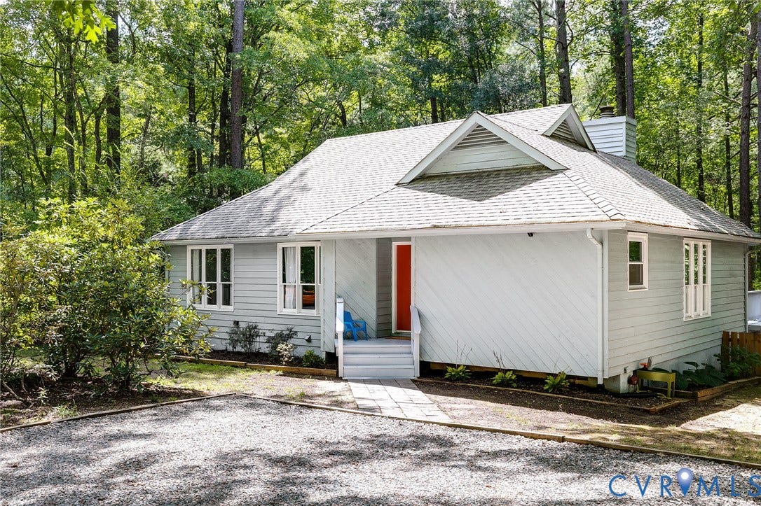 Light grey siding exterior with a red front door, white trim, and a shingle roof
