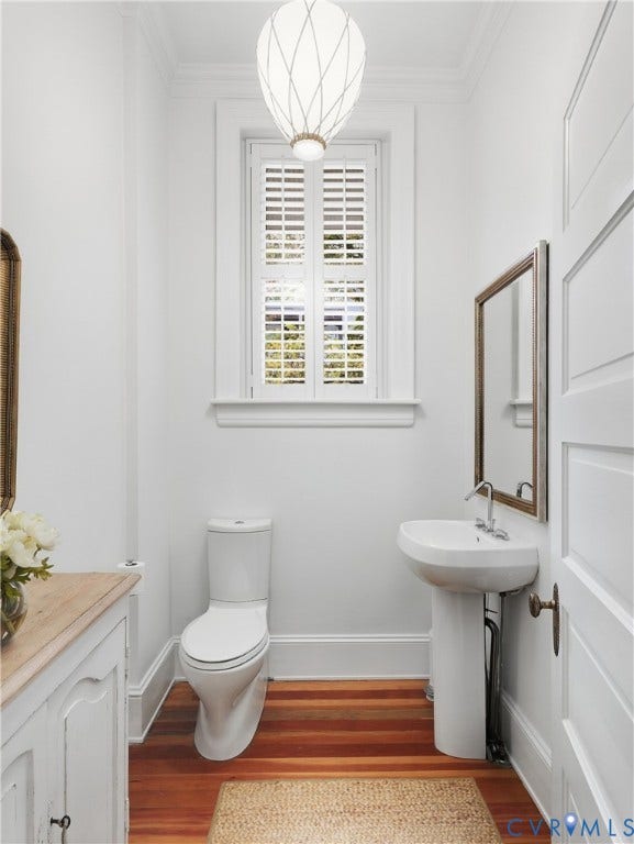1829 Floyd Avenue, The Fan, Richmond, VA 23220 Pedestal sink, wood-finish flooring, plantation shutters, contemporary pendant light, and paneled door