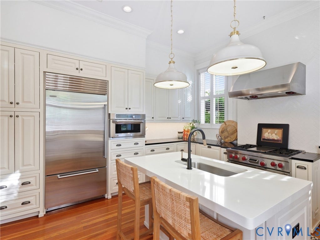 1829 Floyd Avenue, The Fan, Richmond, VA 23220 Gourmet kitchen with stainless steel appliances, white cabinetry, a built-in microwave, a gas range with an overhead exhaust hood, and a central island featuring an undermount sink