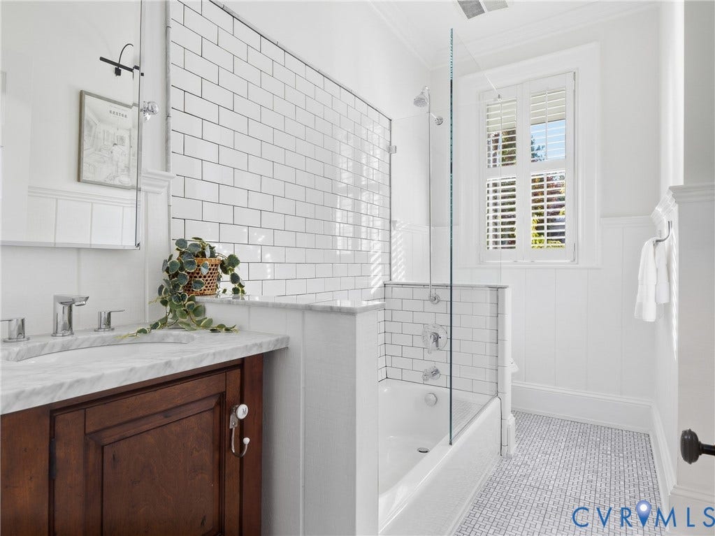 1829 Floyd Avenue, The Fan, Richmond, VA 23220 White subway tile shower surround, glass shower enclosure, wood-finish vanity with countertop, plantation shutters, and patterned floor tiling