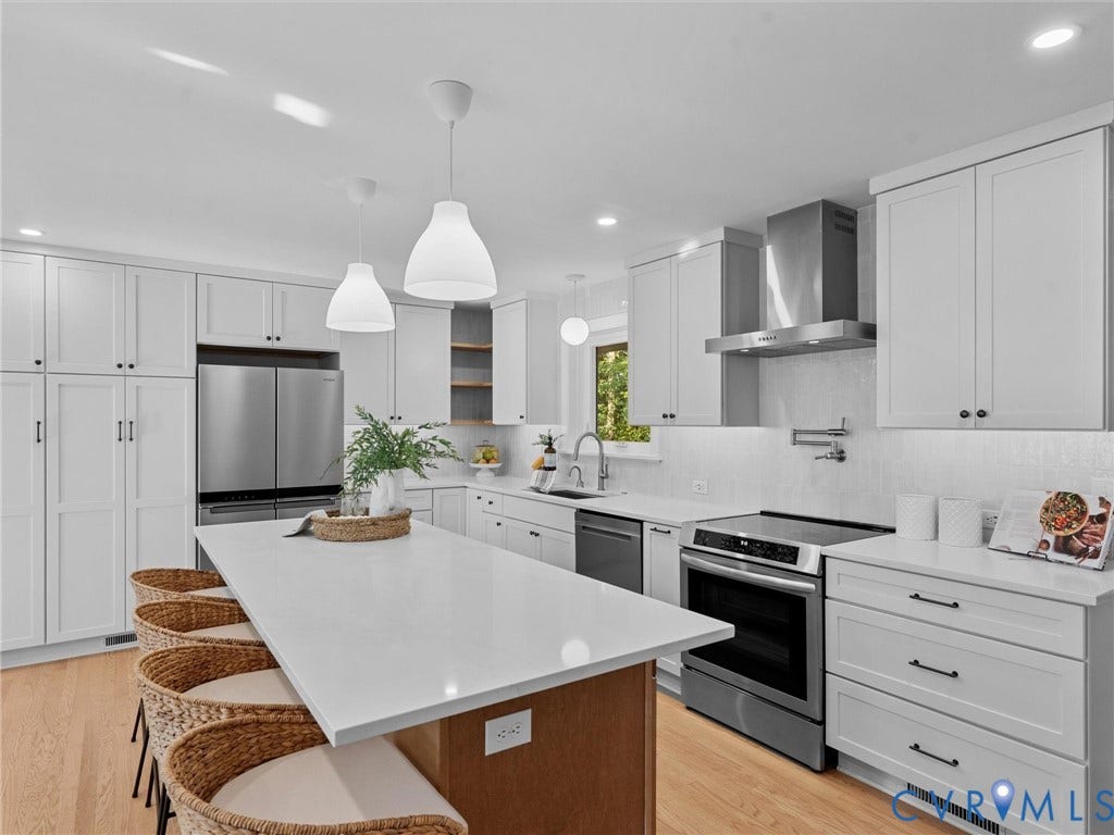 3436 Kenmore Road, Richmond, VA 23225 White shaker cabinetry with black hardware, stainless steel appliances, a large center island with a light-toned countertop, and recessed lighting