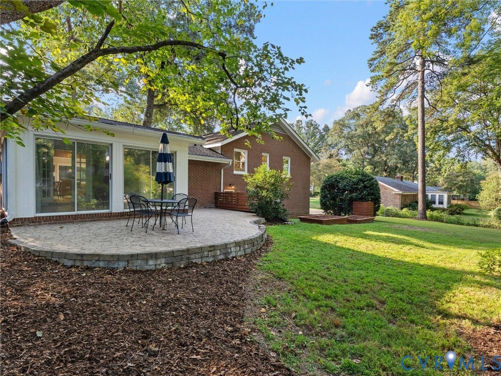 3436 Kenmore Road, Richmond, VA 23225 Brick exterior with a gabled roofline, featuring a stone-paved patio with a low retaining wall