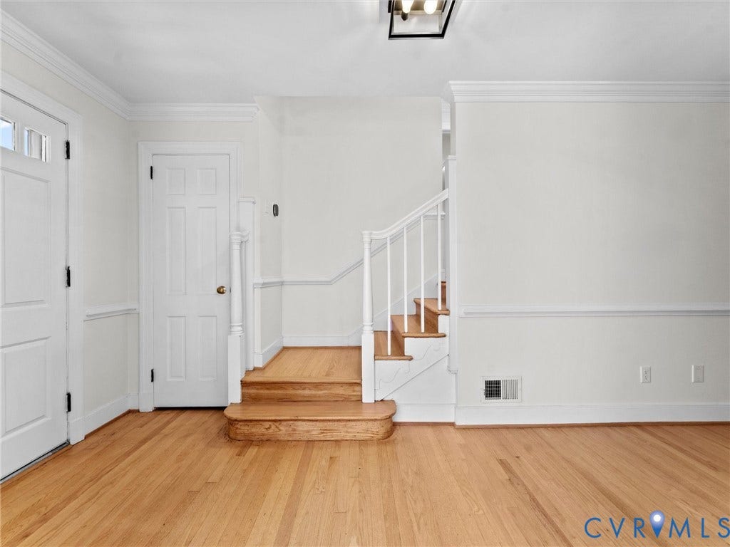 3436 Kenmore Road, Richmond, VA 23225 Hardwood flooring, classic crown molding, wainscoting details, paneled interior doors, and a staircase with white balusters