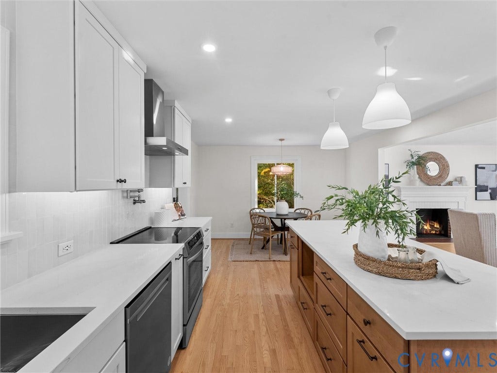 3436 Kenmore Road, Richmond, VA 23225 Modern kitchen featuring white shaker cabinetry, white subway tile backsplash, light wood-finish flooring, a kitchen island with storage, and integrated appliances