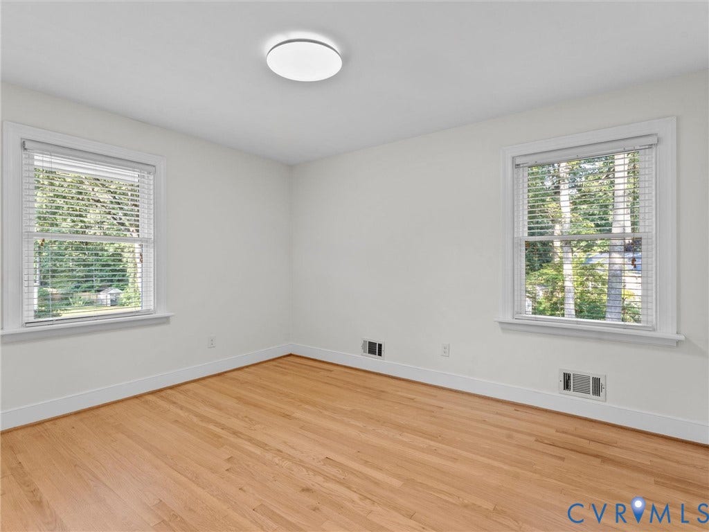 3436 Kenmore Road, Richmond, VA 23225 Hardwood flooring, white walls, two windows, window blinds, and a flush mount ceiling light fixture