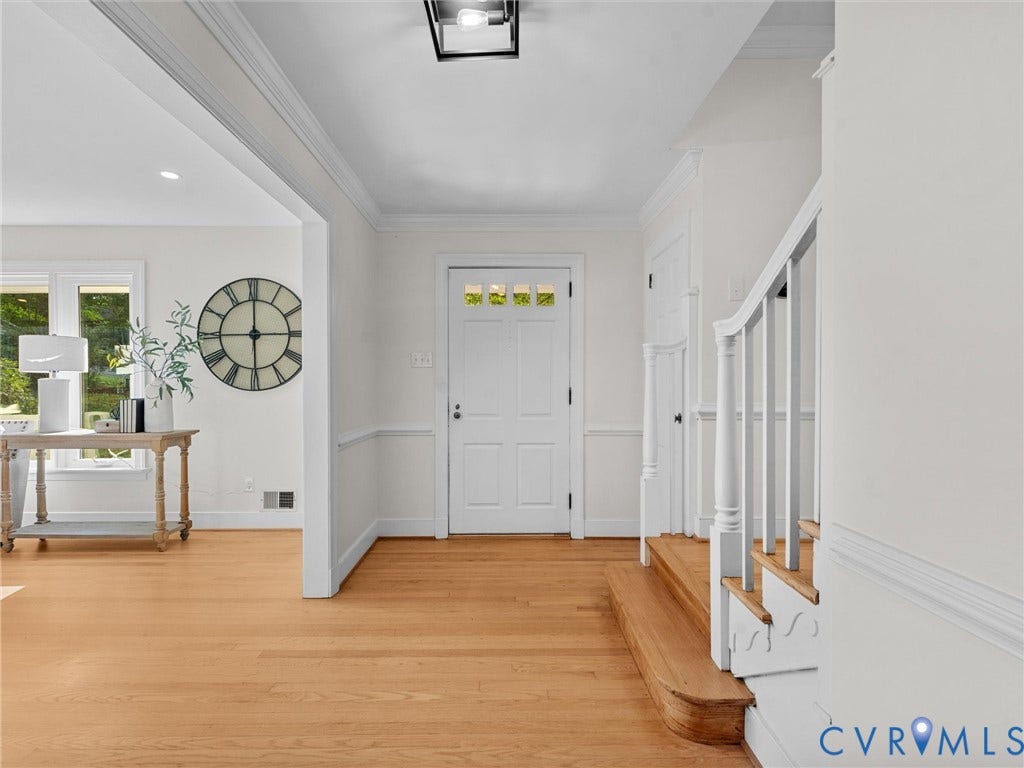 3436 Kenmore Road, Richmond, VA 23225 Hardwood flooring, classic white paneling, white interior door with decorative glass, and a traditional staircase with turned newel posts