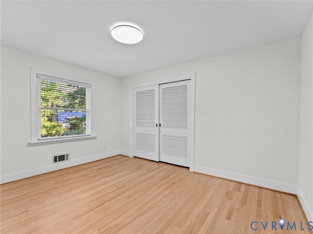 3436 Kenmore Road, Richmond, VA 23225 Light-filled room featuring wood-finish flooring, a double window with white blinds, white walls, white trim, and a white flush-mount ceiling light