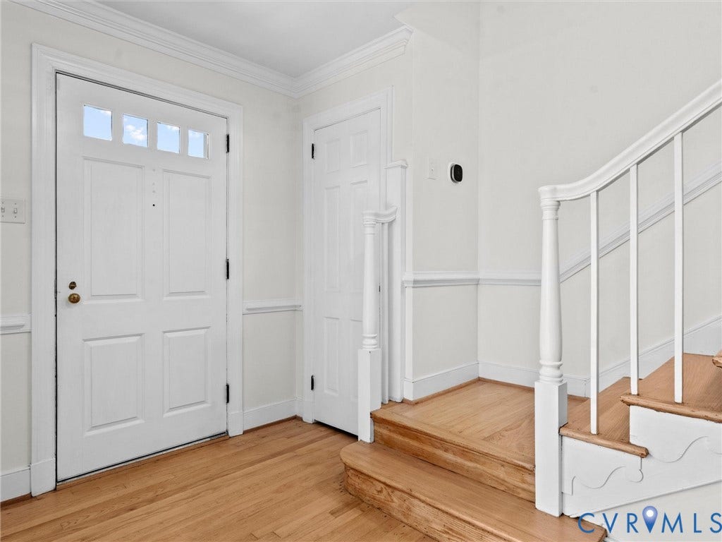 3436 Kenmore Road, Richmond, VA 23225 Panel door with transom window, hardwood flooring, detailed crown molding, wainscoting, and a traditional staircase