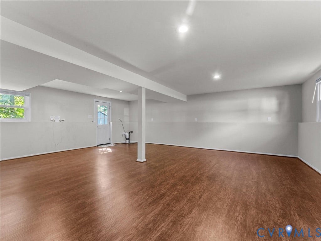 Spacious room featuring wood-finish flooring, recessed lighting, and white walls