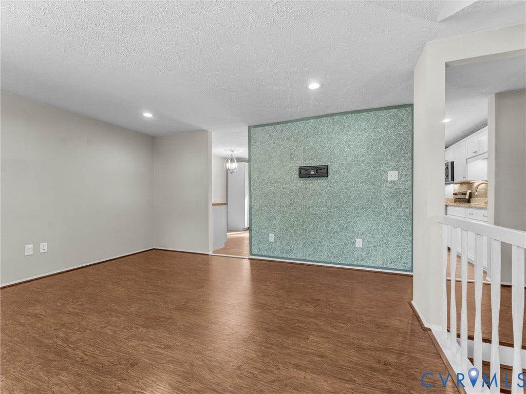 Recessed lighting illuminates wood-finish flooring