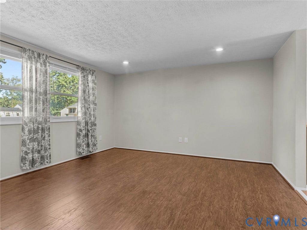 Wood-finish flooring with neutral wall tones and recessed lighting