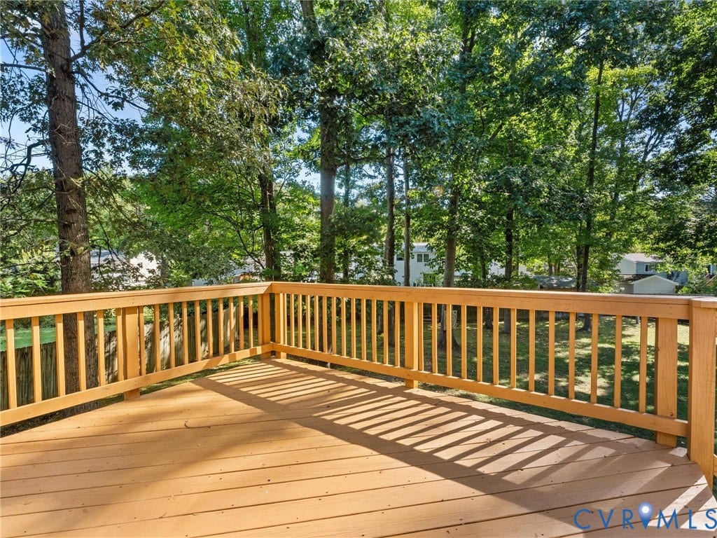 Spacious composite deck featuring pressure-treated wood decking, matching wood-finish railings with vertical balusters, and expansive square footage ideal for entertaining