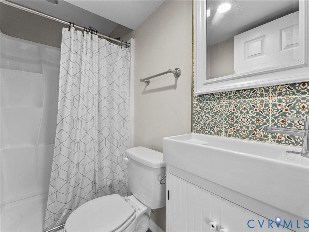 White vanity with beadboard detailing, rectangular basin sink, and patterned backsplash