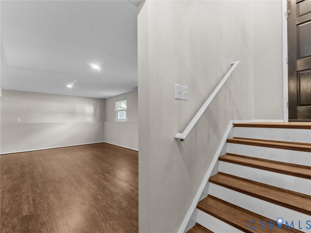 Wood-finish flooring, recessed lighting, and a window provide natural light
