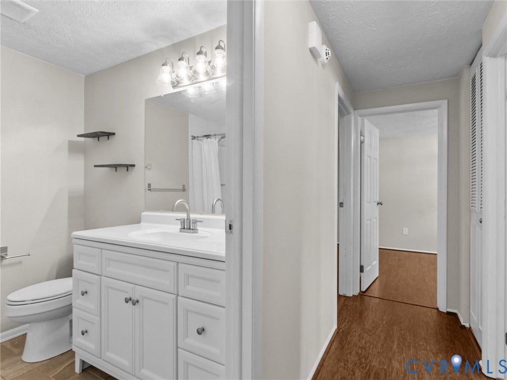 Bathroom vanity with a white countertop and integrated sink, chrome faucet, and cabinet storage