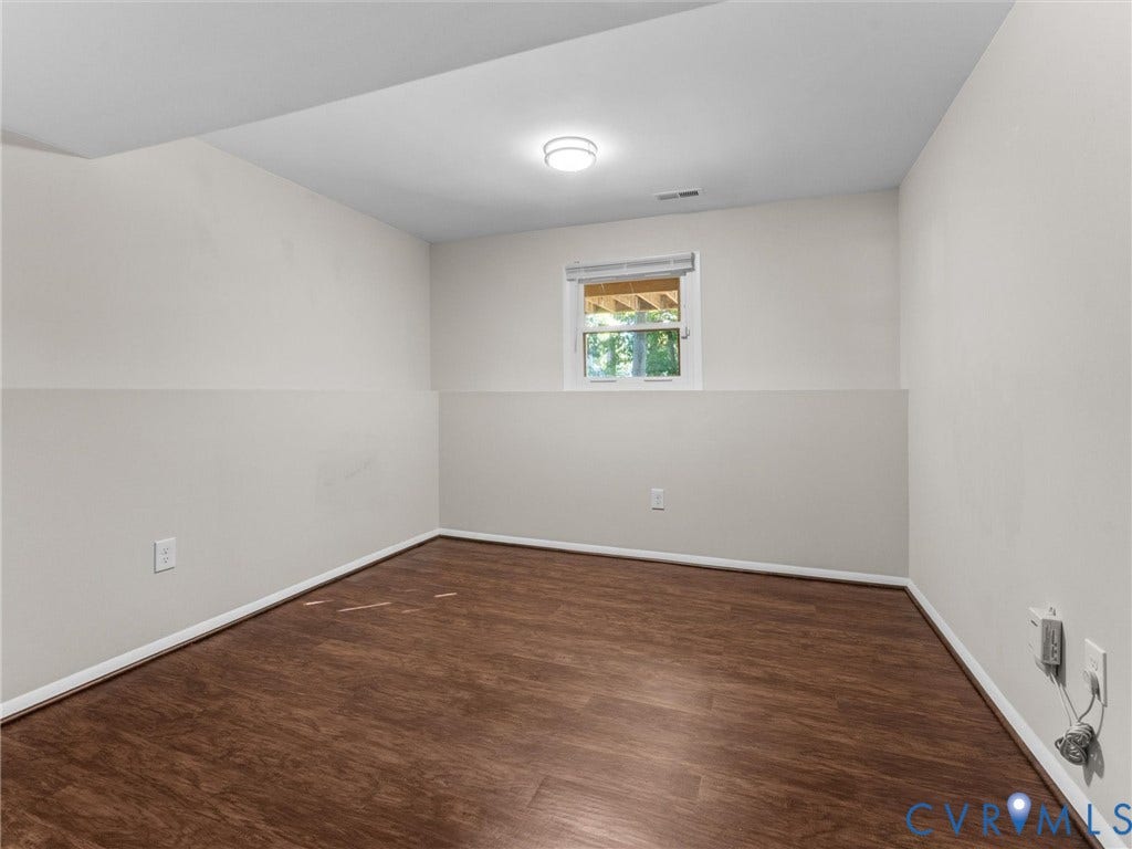 Wood-finish flooring, two-tone painted walls, recessed window, and overhead lighting