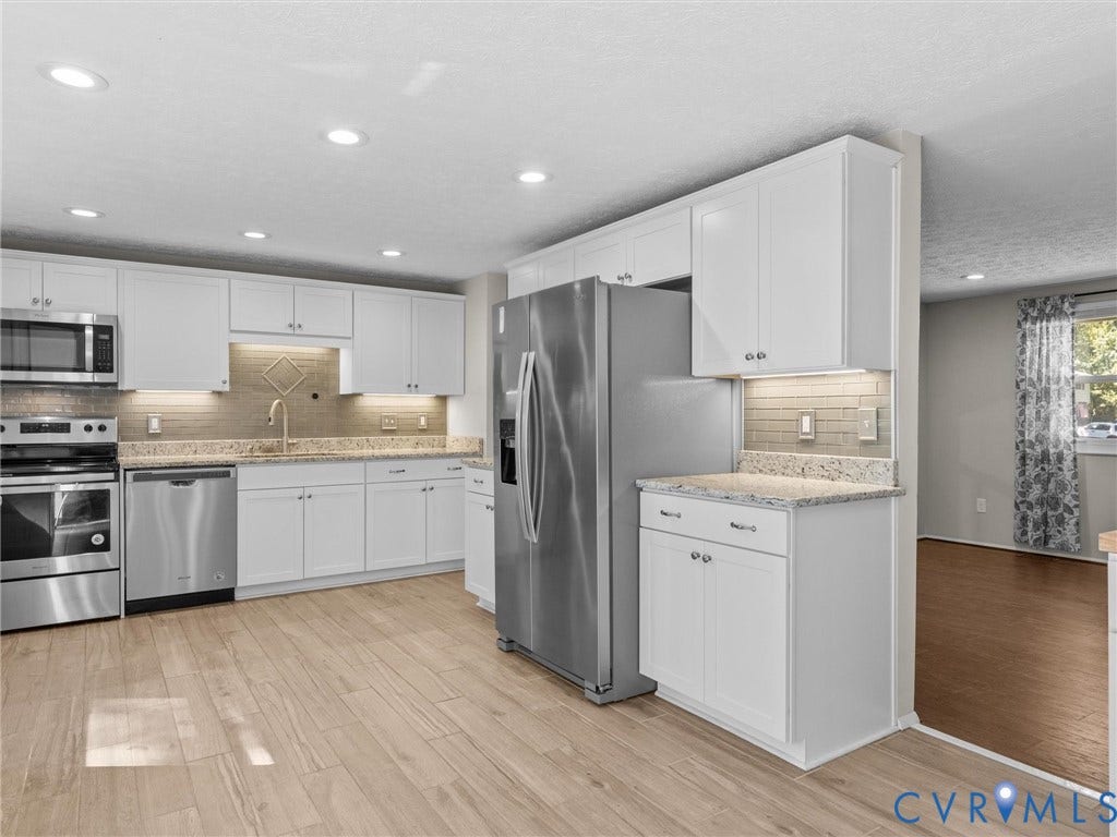 Kitchen featuring white shaker cabinetry, stainless steel appliances, light-toned wood-finish flooring, recessed lighting, and a subway tile backsplash