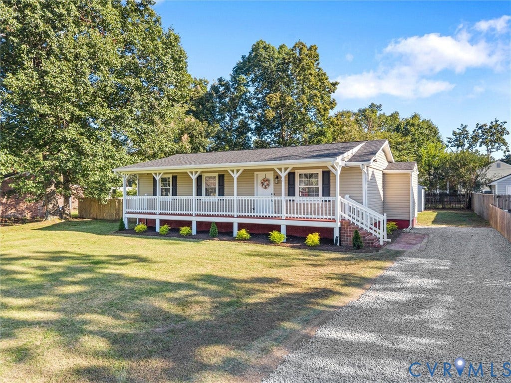 Cottage-style home with a covered front porch, white railing, and exterior siding