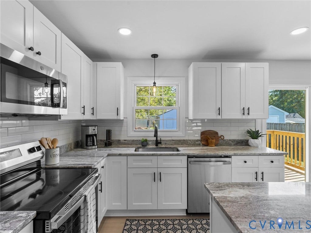 U-shaped kitchen featuring white shaker cabinets, stainless steel appliances, light-toned granite countertops, a subway tile backsplash, and a single-basin sink with a matte black faucet