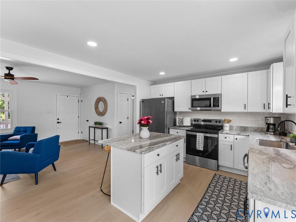 Kitchen featuring white shaker cabinetry, stainless steel appliances, light-toned wood-finish flooring, a kitchen island with stone countertop, and a subway tile backsplash