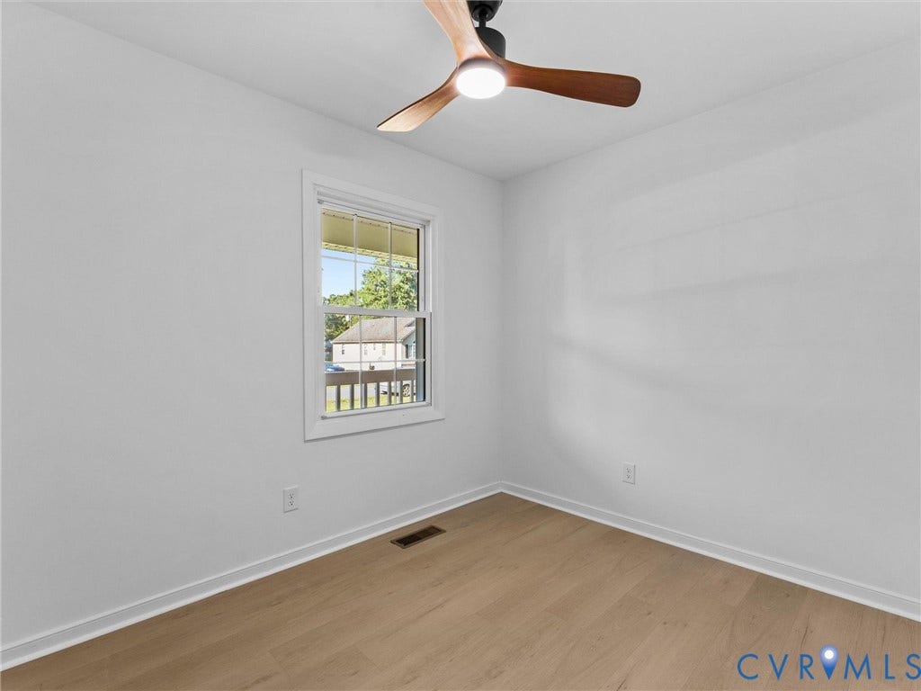 Wood-finish flooring, white walls, and a modern ceiling fan with integrated lighting