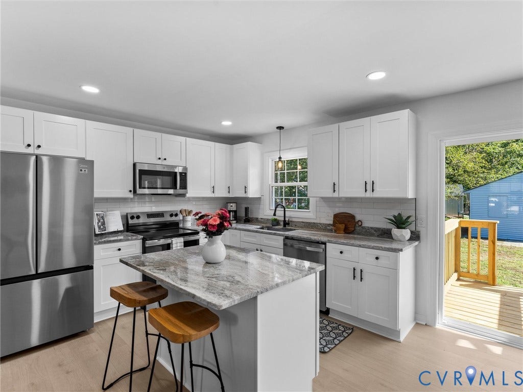Kitchen featuring white cabinetry, stainless steel appliances, a center island with a stone countertop, a tile backsplash, and wood-finish flooring