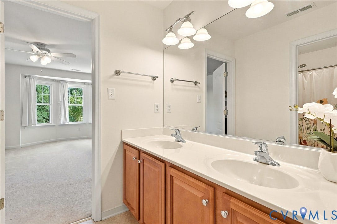 Dual vanity with integrated sinks, chrome fixtures, and a light-colored countertop
