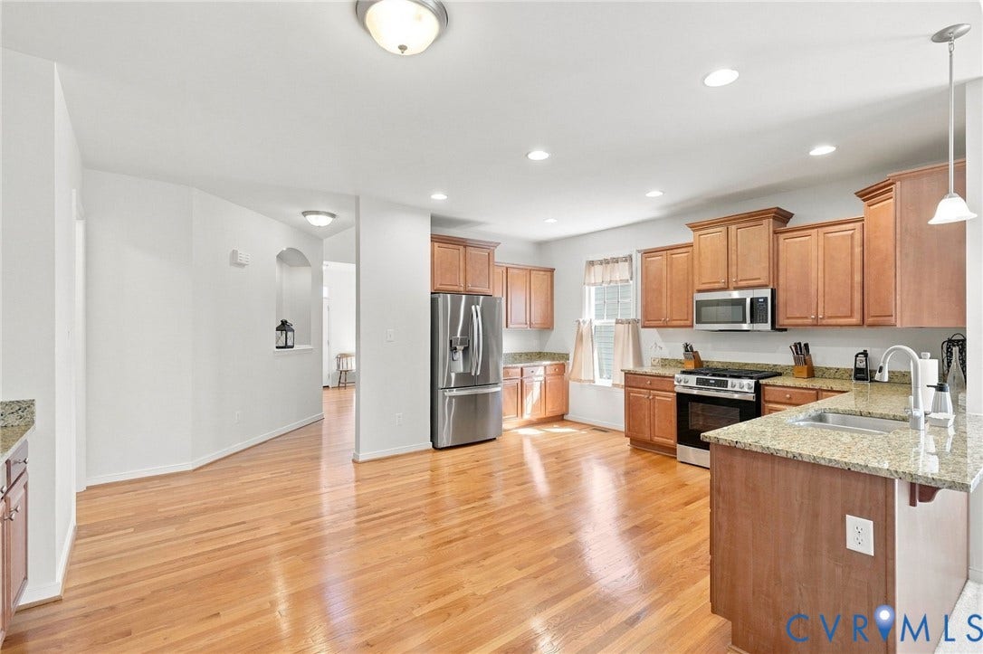 Kitchen featuring wood-finish flooring, granite countertops, stainless steel appliances, recessed lighting, and wood cabinetry